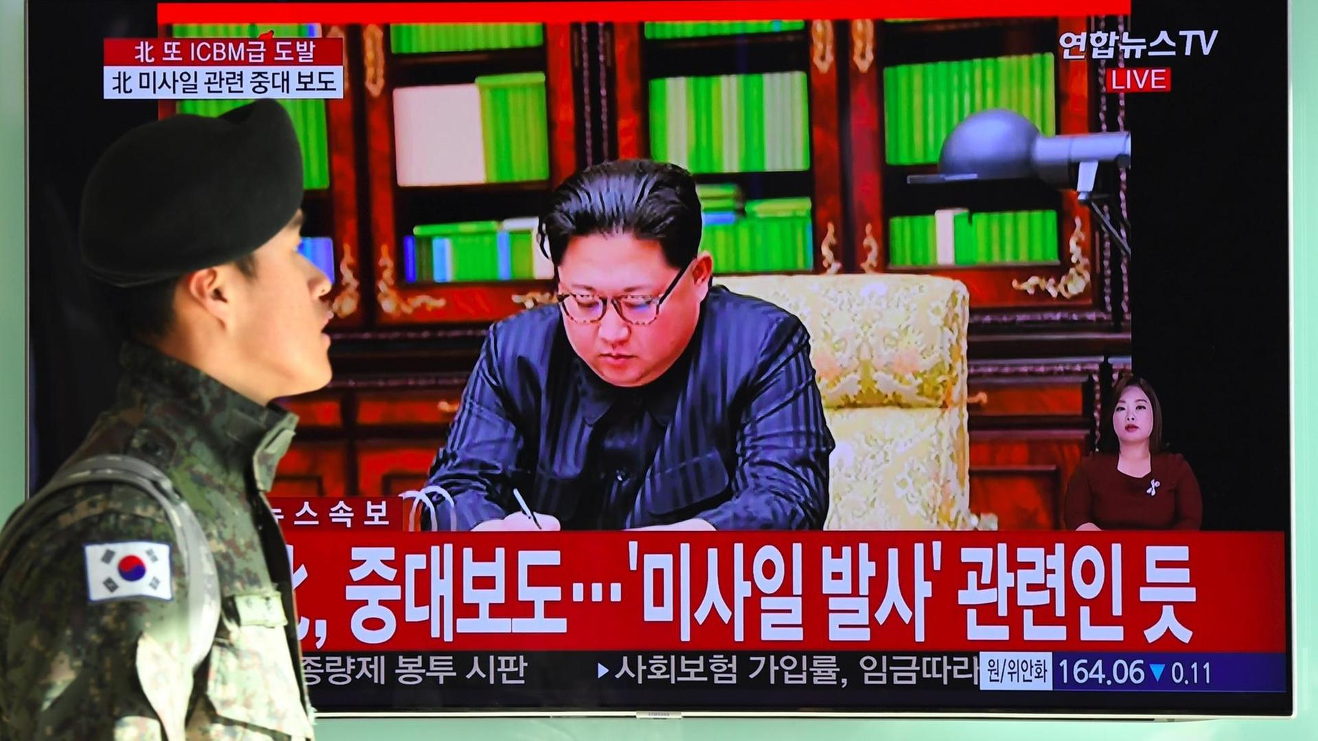 Ein Soldat in Südkorea vor einem Fernseher, in dem Nordkoreas Machthaber Kim Jong Un über den jüngsten Raketentest des Landes spricht. Ein Soldat in Südkorea vor einem Fernseher, in dem Nordkoreas Machthaber Kim Jong Un über den jüngsten Raketentest des Landes spricht.