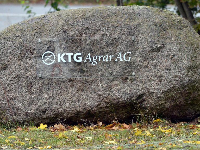 Ein Schild auf einem Feldstein weist in Oranienburg (Brandenburg) auf die Niederlassung der KTG Agrar SE hin.
