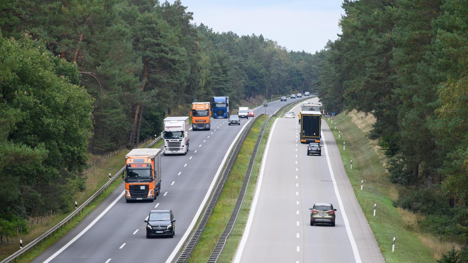Lastwagen und Autos fahren nahe der Abfahrt Lanke auf der Autobahn A 10 in beiden Richtungen. Lastwagen und Autos fahren nahe der Abfahrt Lanke auf der Autobahn A 10 in beiden Richtungen.