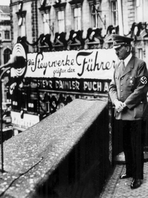 Der Führer und Reichskanzler Adolf Hitler (l) schaut mit Propagandaminister Dr. Joseph Goebbels am 14. März 1938, einen Tag nach dem Einmarsch der deutschen Wehrmacht in Österreich, vom Balkon des Hotels Imperial in Wien am Schwarzenbergplatz auf die ihm zujubelnde Menge, die sich vor dem Hotel versammelt hat.