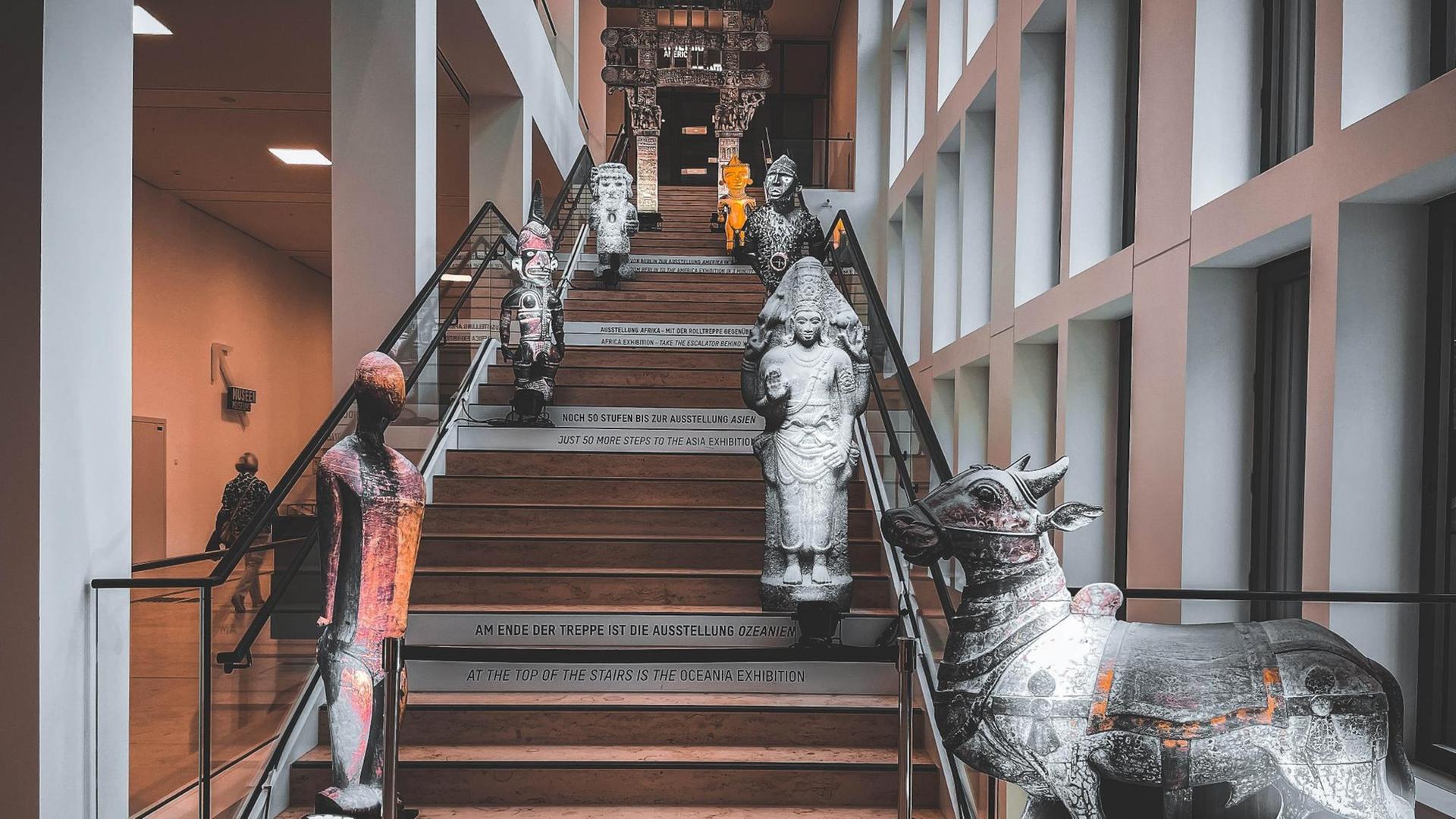 Auf einer Treppe stehen Statuen von Menschen und Tieren. Auf einer Treppe stehen Statuen von Menschen und Tieren.