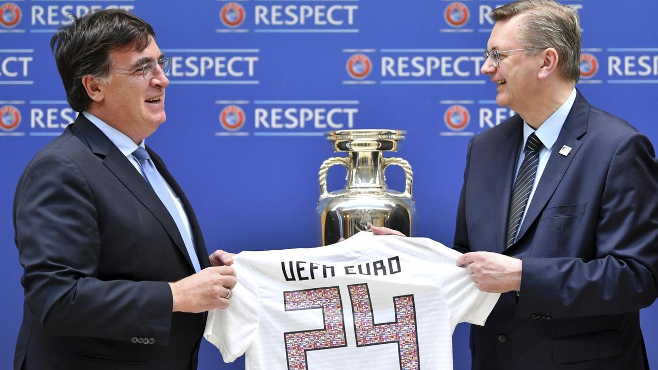 DFB-Präsident Reinhard Grindel (r.) bei der Übergabe der die Bewerbungsunterlagen für die EM 2024 mit UEFA-Generalsekretär Theodore Theodoridis in Nyon (Schweiz).