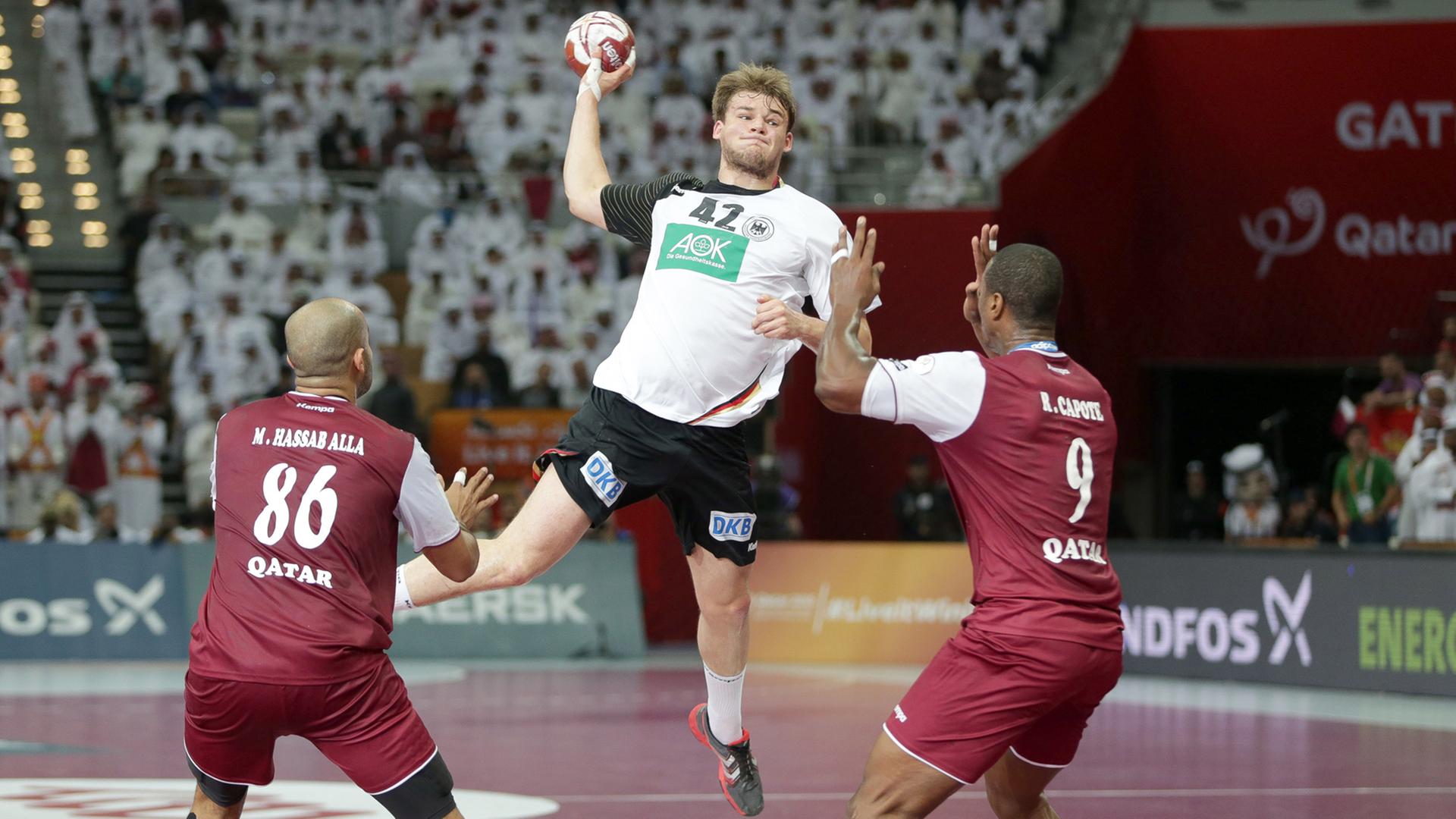 Zwei Spieler der Gastgeber bei der Handball-WM in Katar im Kampf gegen Paul Drux. Zwei Spieler der Gastgeber bei der Handball-WM in Katar im Kampf gegen Paul Drux.