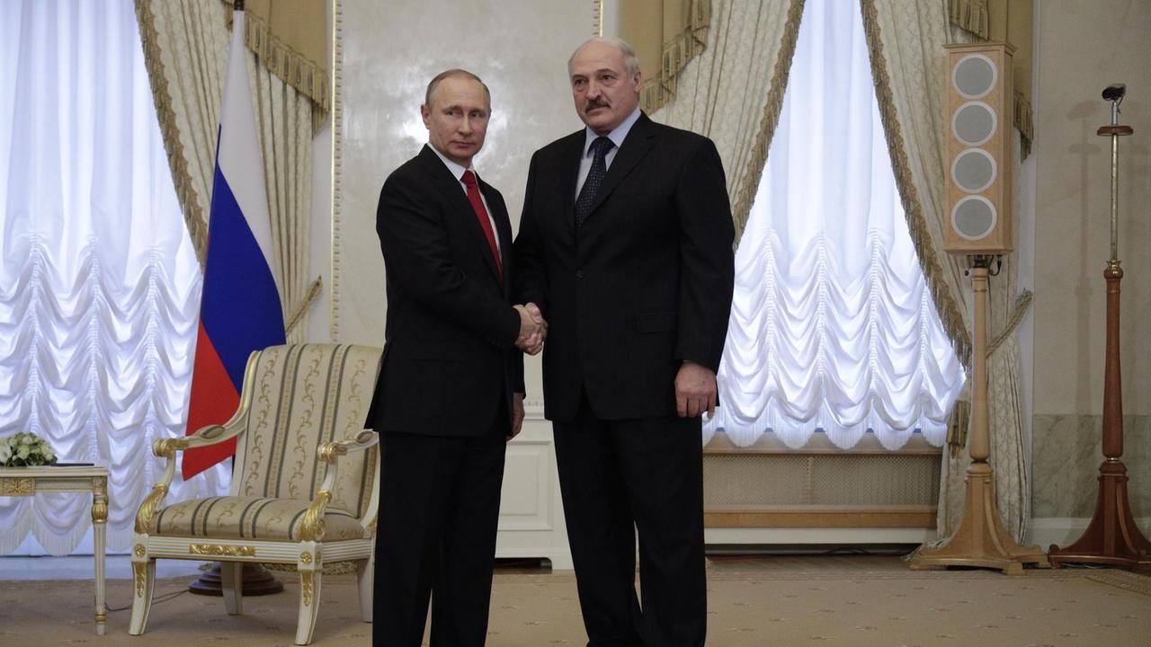 Das Bild zeigt den russischen Präsidenten Wladimir Putin am 03.04.2017 bei einem Treffen in St. Petersburg (Russland) neben dem weißrussischen Präsidenten Alexander Lukaschenko. Beide schauen in die Kamera und geben sich die Hand. Das Bild zeigt den russischen Präsidenten Wladimir Putin am 03.04.2017 bei einem Treffen in St. Petersburg (Russland) neben dem weißrussischen Präsidenten Alexander Lukaschenko. Beide schauen in die Kamera und geben sich die Hand.