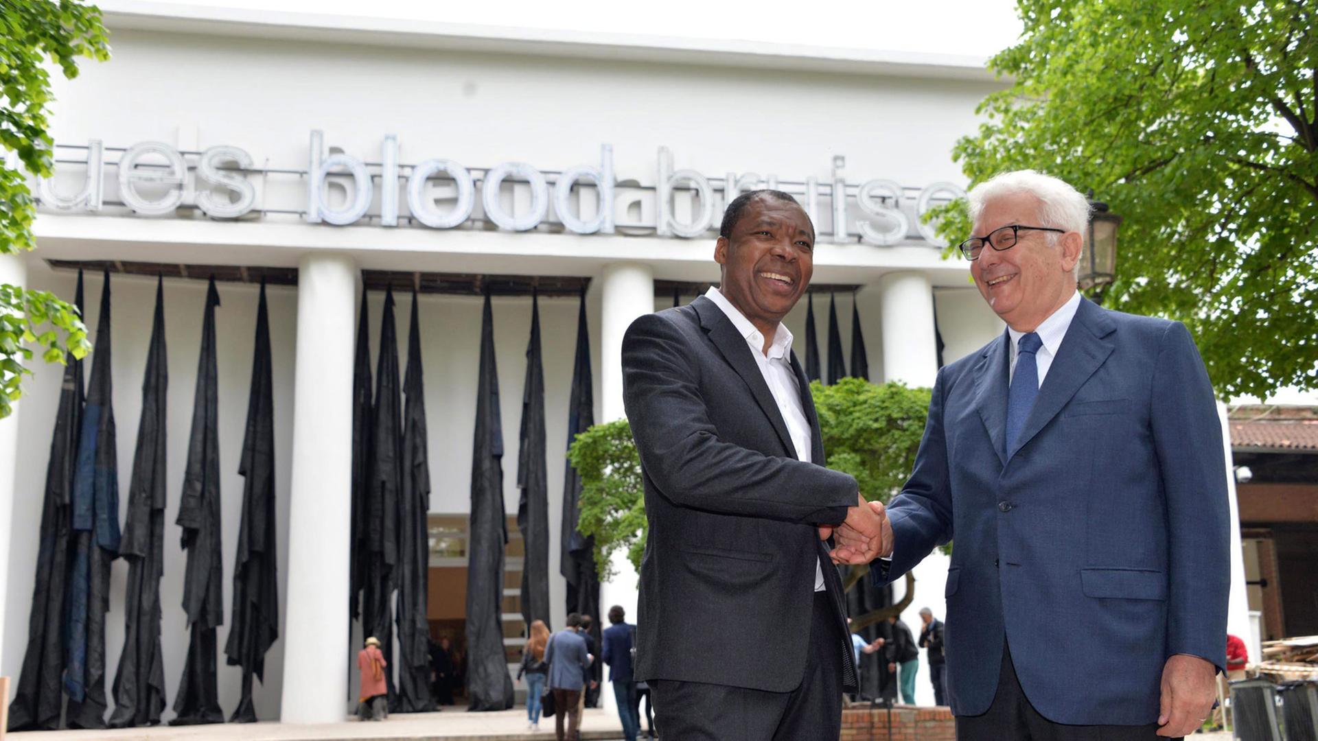 Der künstlerische Leiter Okwui Enwezor (l) und der Biennale-Präsident Paolo Baratta posieren am 5.5.2015 auf der 56. Kunstbiennale, die vom 9.5. bis 22.1.2015 in Venedig stattfindet. Der künstlerische Leiter Okwui Enwezor (l) und der Biennale-Präsident Paolo Baratta posieren am 5.5.2015 auf der 56. Kunstbiennale, die vom 9.5. bis 22.1.2015 in Venedig stattfindet.