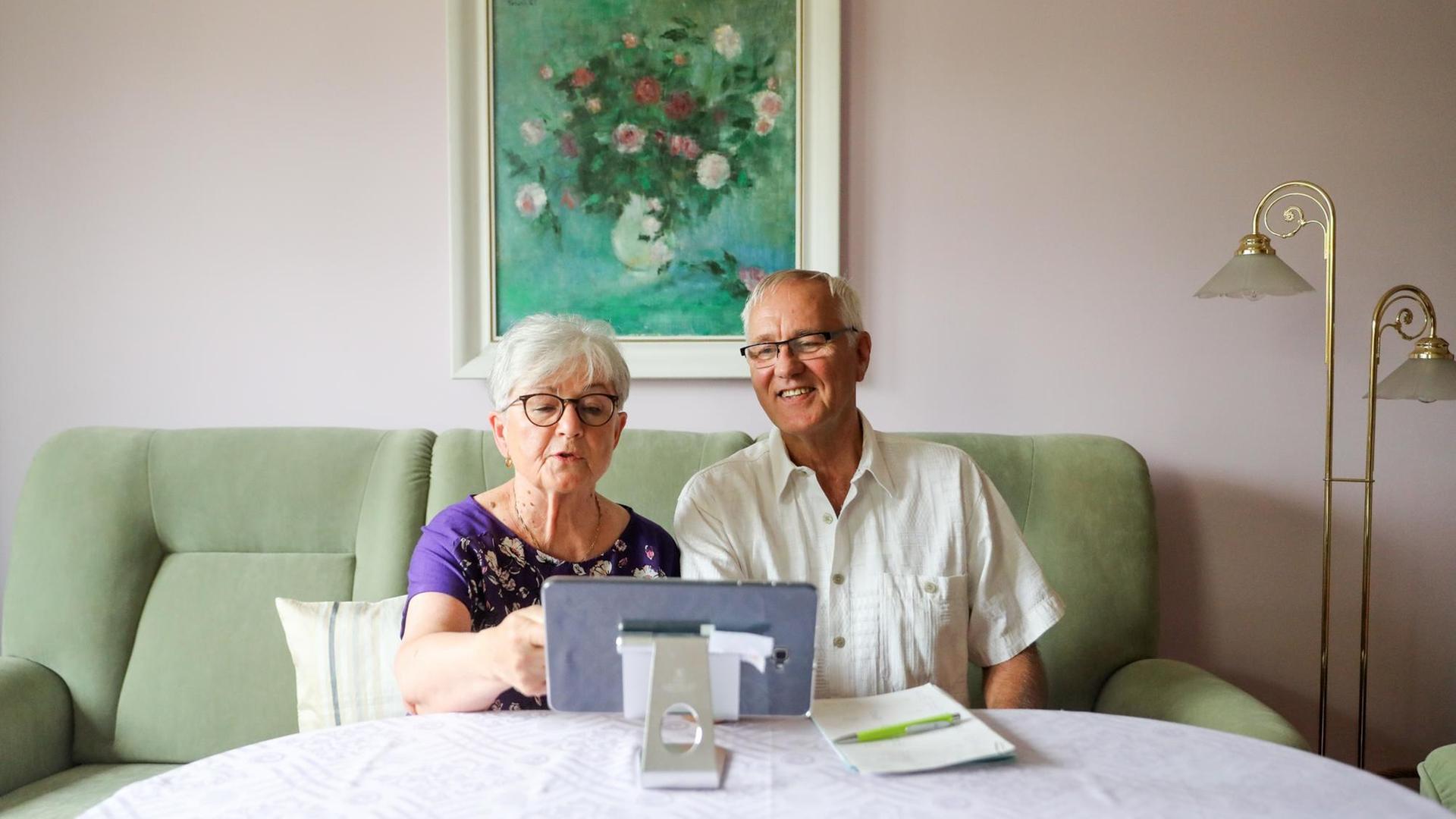Die Rentner Siglinde und Norbert Neumann benutzen ein Tablet für die Kommunikation mit ihrem Hausarzt.