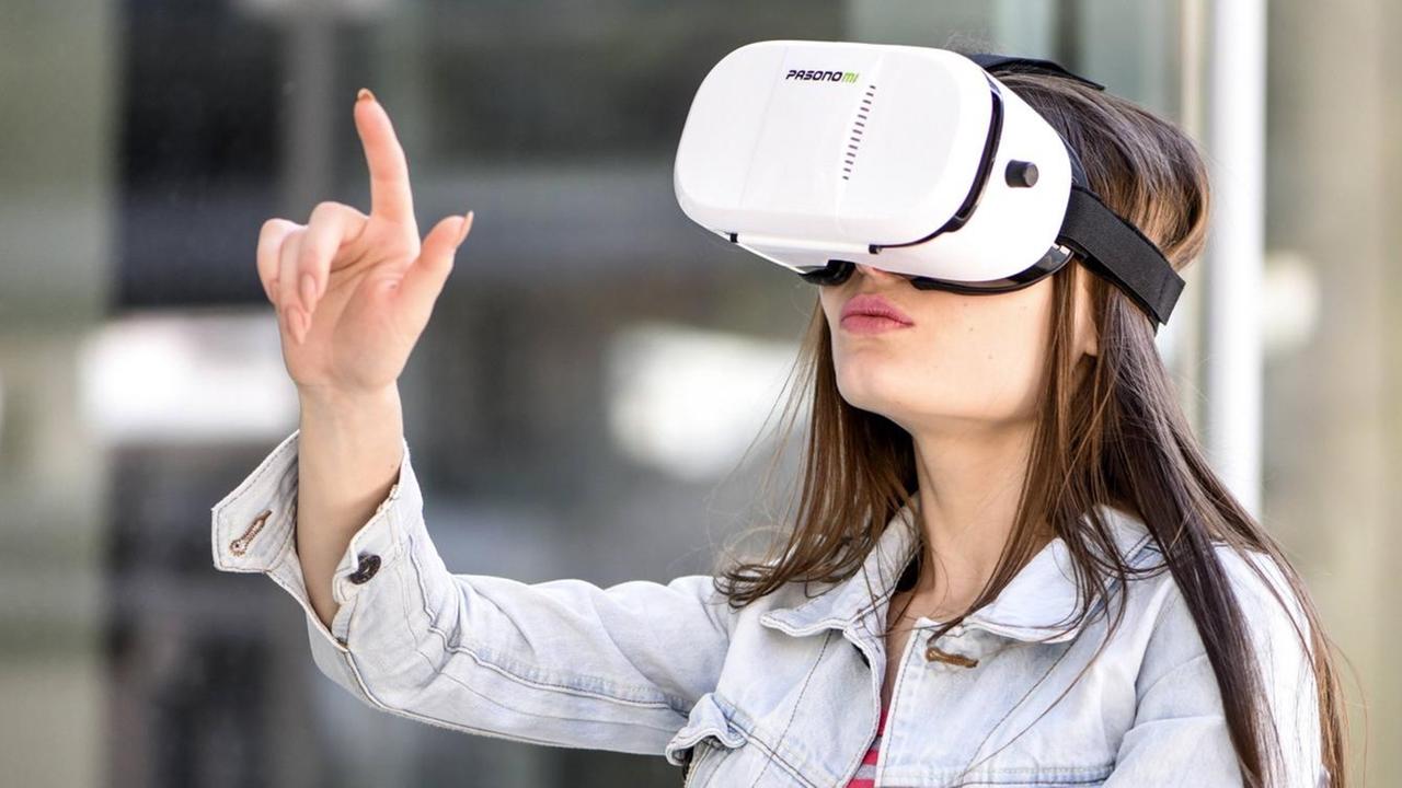 Junge Frau mit VR-Brille zeigt mit dem Finger in die Luft. Junge Frau mit VR-Brille zeigt mit dem Finger in die Luft.