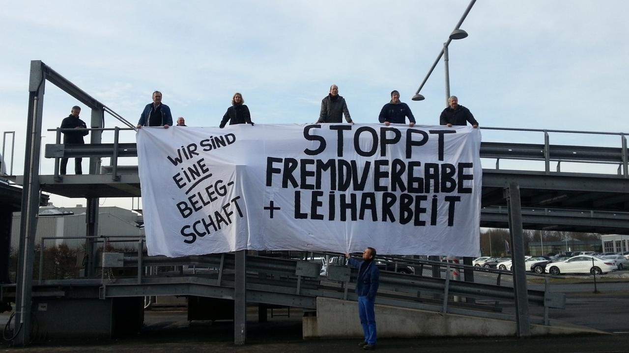 Menschen streiken mit einem Transparent in den Händen gegen Lohnarbeit und Fremdvergabe. Menschen streiken mit einem Transparent in den Händen gegen Lohnarbeit und Fremdvergabe.