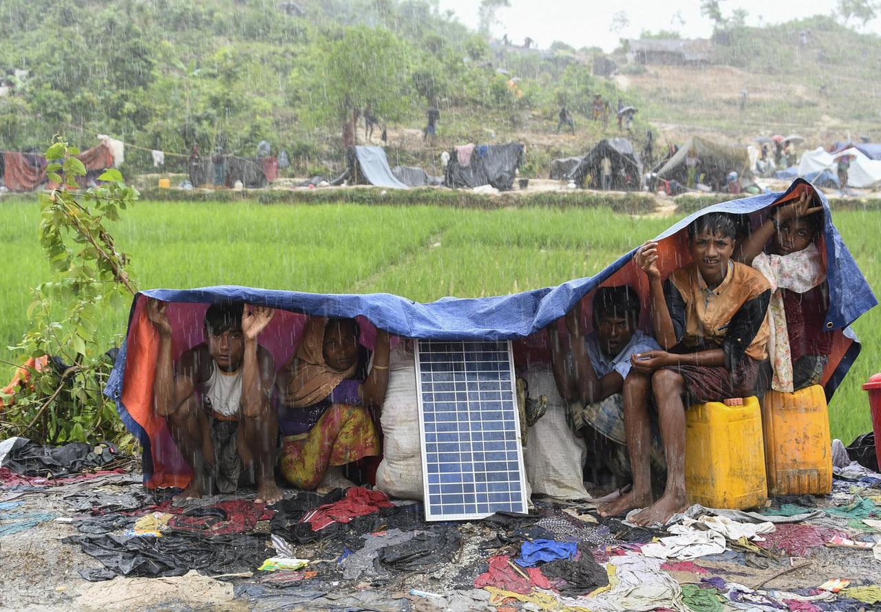 Angehörige der Rohingya schützen sich in einem Flüchtlingslager in Bangladesch vor Monsun-Regen