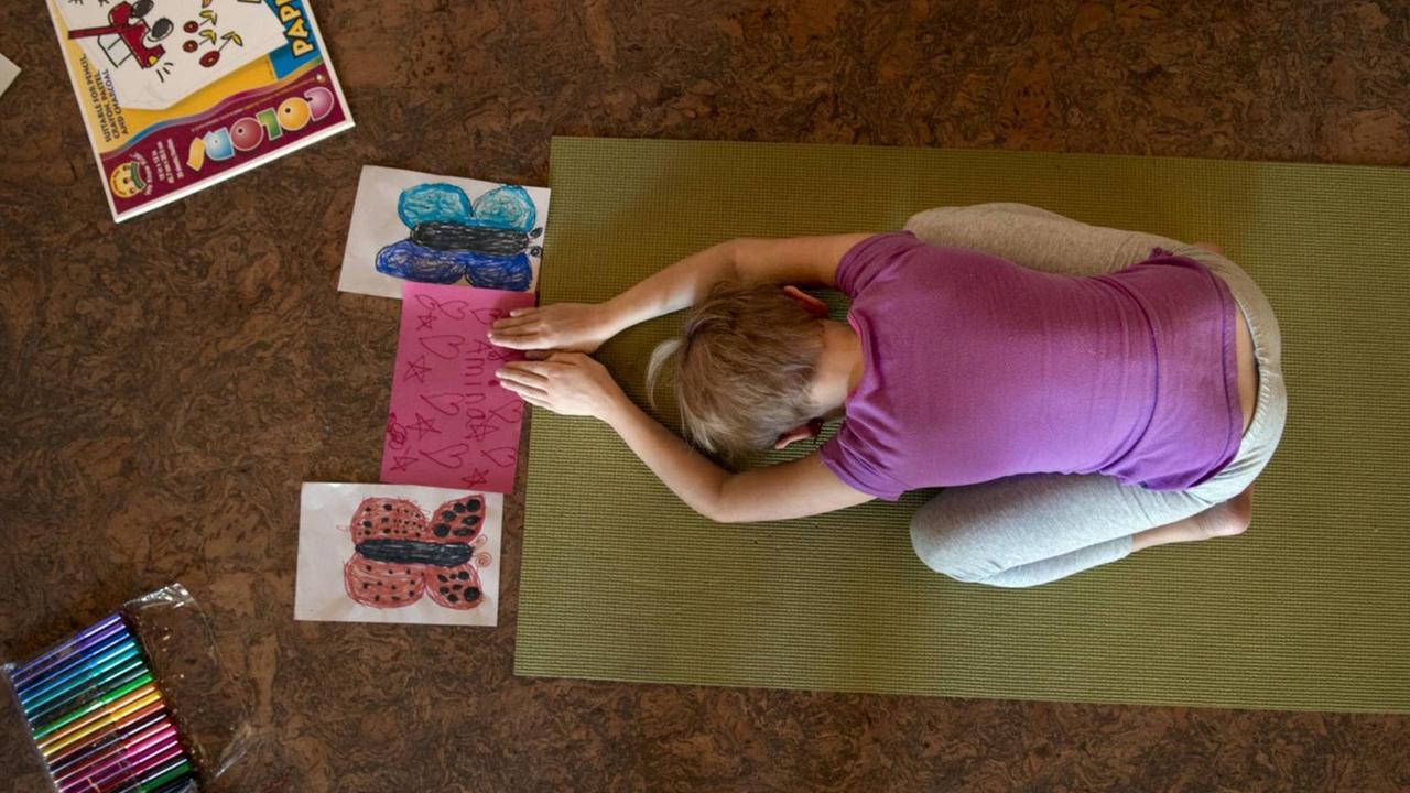 Ein Mädchen macht eine Yoga-Übung in einem US-amerikanischen Yoga-Camp in Sacramento (Kalifornien). Ein Mädchen macht eine Yoga-Übung in einem US-amerikanischen Yoga-Camp in Sacramento (Kalifornien).