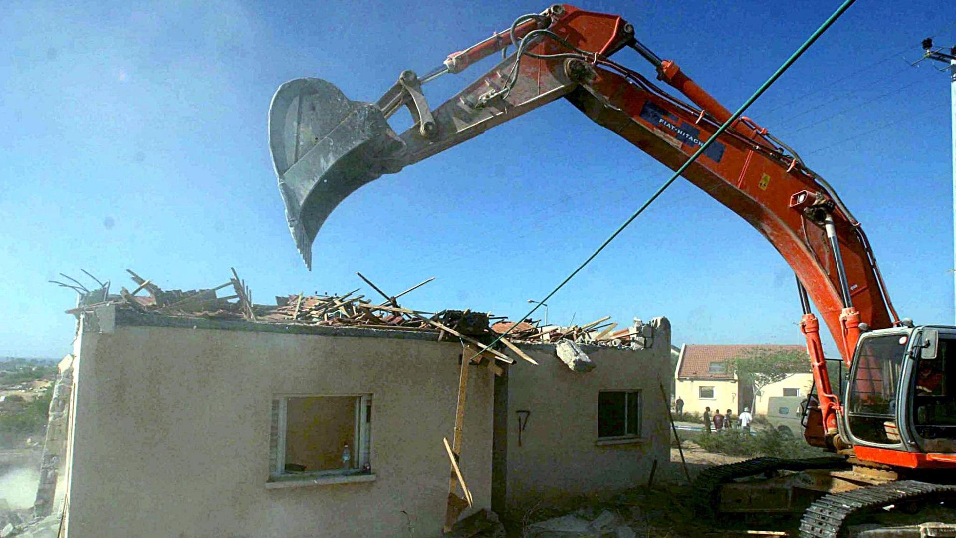 21.8.2005: Nach dem Abzug der Siedler lassen die israelischen Behörden die Siedlungsgebäude in Peat Sadeh, Gush Katif, Gazastreifen, abreißen. Das Bild zeigt einen Bagger, der ein Haus einreißt. 21.8.2005: Nach dem Abzug der Siedler lassen die israelischen Behörden die Siedlungsgebäude in Peat Sadeh, Gush Katif, Gazastreifen, abreißen. Das Bild zeigt einen Bagger, der ein Haus einreißt.