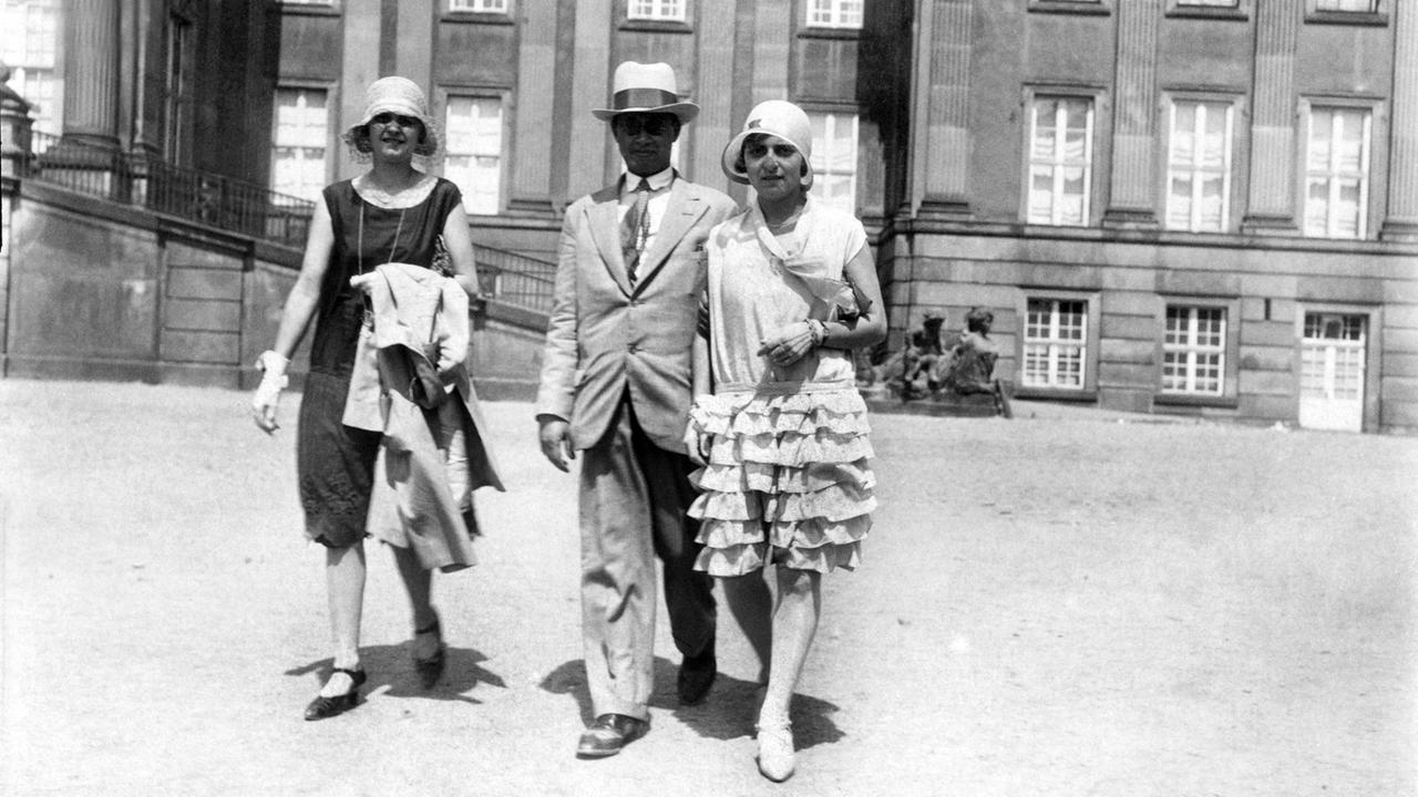 Historische Aufnahme: Ein Mann und zwei Frauen flanieren. Historische Aufnahme: Ein Mann und zwei Frauen flanieren.