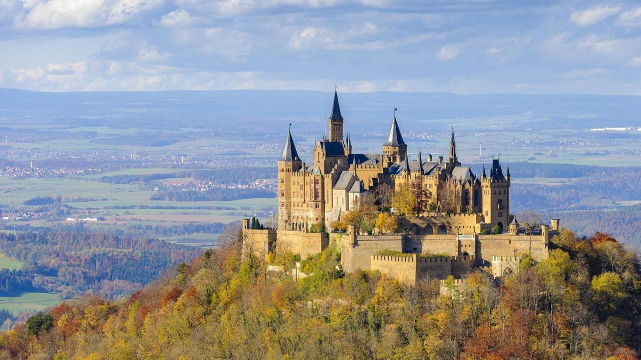 Das Bild zeigt die Burg Hohenzollern auf der schwäbischen Alb im Herbst vor einem Himmel mit vielen Wolken. Das Bild zeigt die Burg Hohenzollern auf der schwäbischen Alb im Herbst vor einem Himmel mit vielen Wolken.