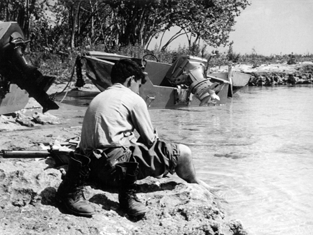 Neben zerstörten Landungsbooten der Invasionstruppen kühlt sich ein siegreicher Castro-Soldat in der Schweinebucht 1961 die Füße im Wasser. Neben zerstörten Landungsbooten der Invasionstruppen kühlt sich ein siegreicher Castro-Soldat in der Schweinebucht 1961 die Füße im Wasser.