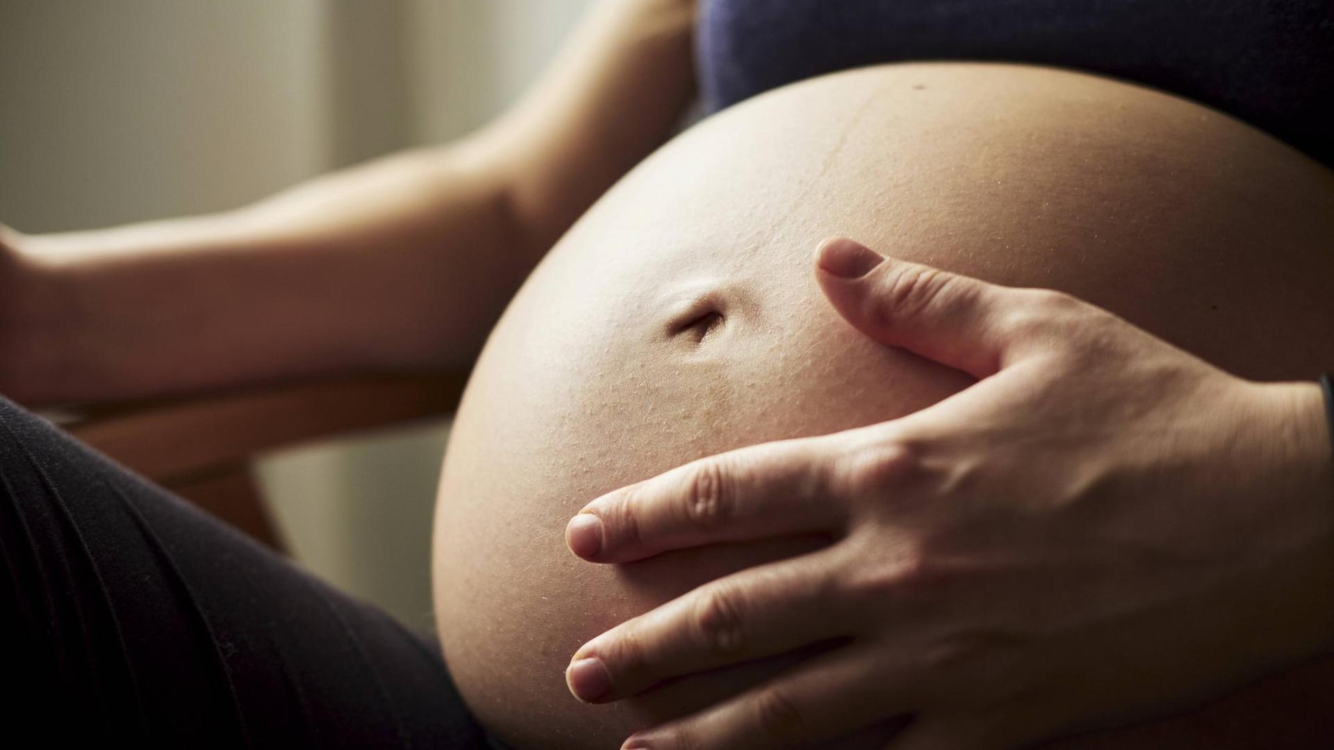 Eine schwangere Frau legt ihre Hand auf den Bauch (Symbolfoto). Eine schwangere Frau legt ihre Hand auf den Bauch (Symbolfoto).