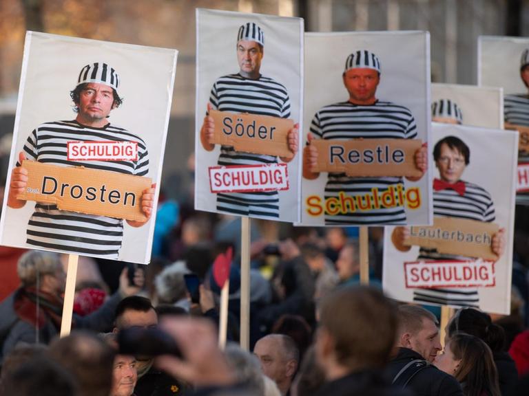 Schilder mit Foto-Montagen von Drosten, Söder, Restle, Lauterbach, Esken und anderen in Sträflingskluft und mit dem Wort "schuldig" werden von Teilnehmern der Demonstration der Stuttgarter Initiative "Querdenken" hoch gehalten. Bei der Demonstration "Querdenken" in Leipzig, 7. November 2020.