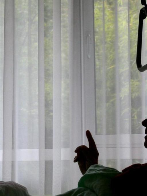 Eine Krankenschwester des Christophorus Hospiz in München versorgt einen sterbenskranken Bewohner