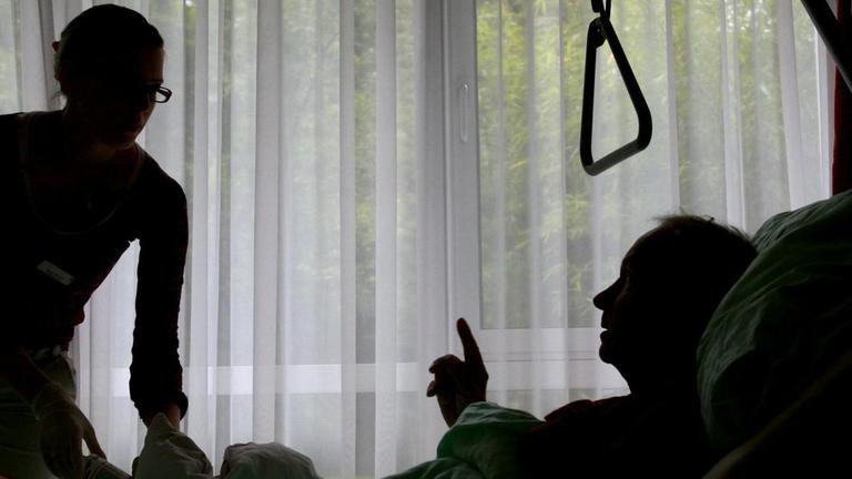 Eine Krankenschwester des Christophorus Hospiz in München versorgt einen sterbenskranken Bewohner