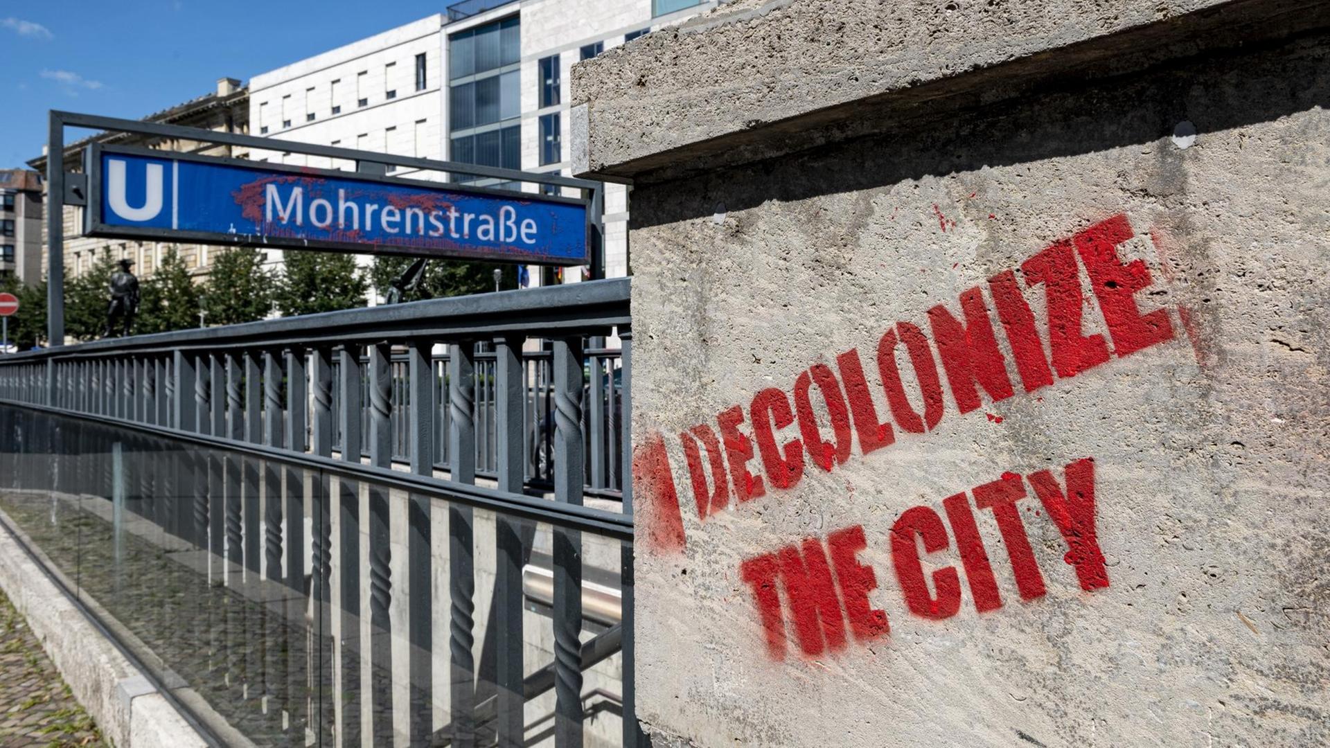 30.07.2020, Berlin: Vor dem Eingang der U-Bahnstation Mohrenstraße hat jemand mit roter Farbe "decolonize the city" an die Wand geschrieben. 30.07.2020, Berlin: Vor dem Eingang der U-Bahnstation Mohrenstraße hat jemand mit roter Farbe "decolonize the city" an die Wand geschrieben.