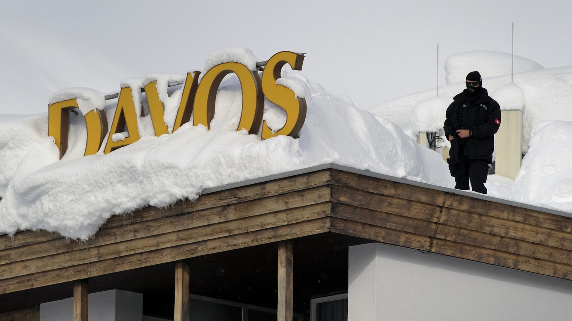 Ein Polizist steht auf dem Dach eines Hotels in der Nähe des Kongresszentrums des World Economic Forums (WEF) im Schweizer Kurort Davos. Ein Polizist steht auf dem Dach eines Hotels in der Nähe des Kongresszentrums des World Economic Forums (WEF) im Schweizer Kurort Davos.
