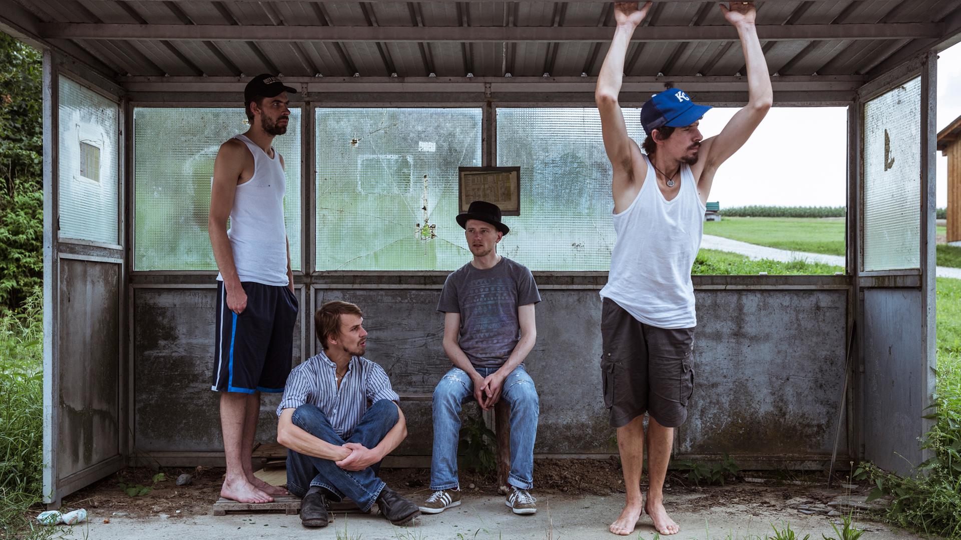 Die Mitglieder der Band "Kofelgschroa" stehen und hocken in einer alten Bushaltestelle Die Mitglieder der Band "Kofelgschroa" stehen und hocken in einer alten Bushaltestelle