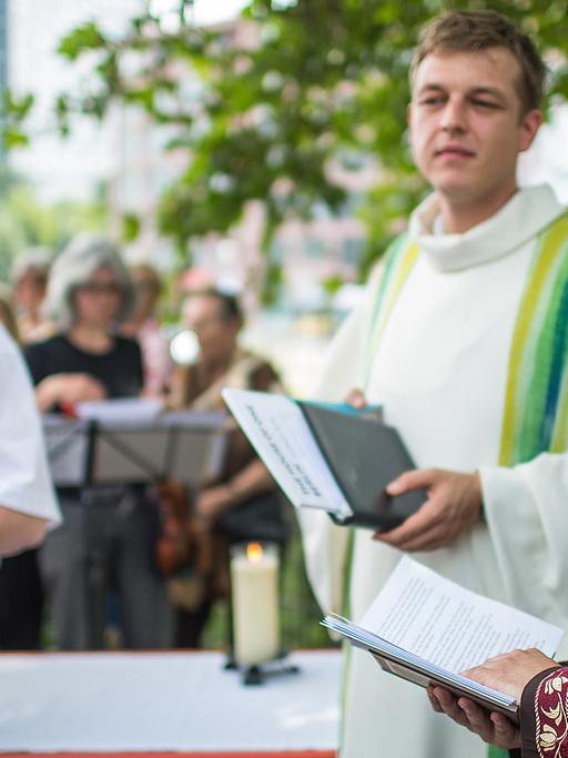 Ein Vertreter für das Judentum, Jan Aaron Voss (von links) von der Werkstatt der Religionen, Pfarrer Eric Haußmann und Iman Kadir Sanci veranstalten ein Friedensgebet in Berlin.