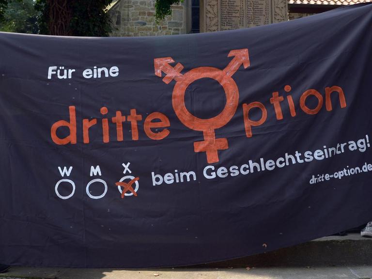 Zwei Personen halten ein Banner, auf dem steht: "Für eine dritte Option beim Geschlechtseintrag"