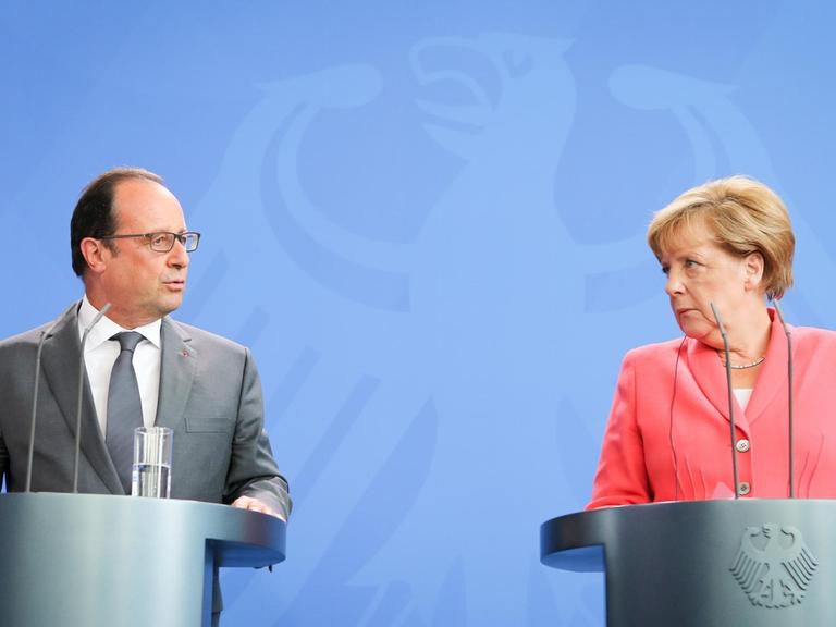 Bundeskanzlerin Angela Merkel (CDU) und Frankreichs Präsident Francois Hollande sprechen am 24.08.2015 in Berlin im Bundeskanzleramt vor einem Treffen zu den Medienvertretern.