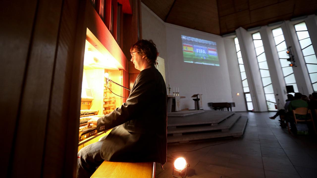 Stummfilmpianist Stephan Graf von Bothmer begleitet am 13.06.2014 auf der Orgel anstelle des Reporter-Kommentars in der Emmaus-Kirche in Berlin die Weltmeisterschaftsbegegnung