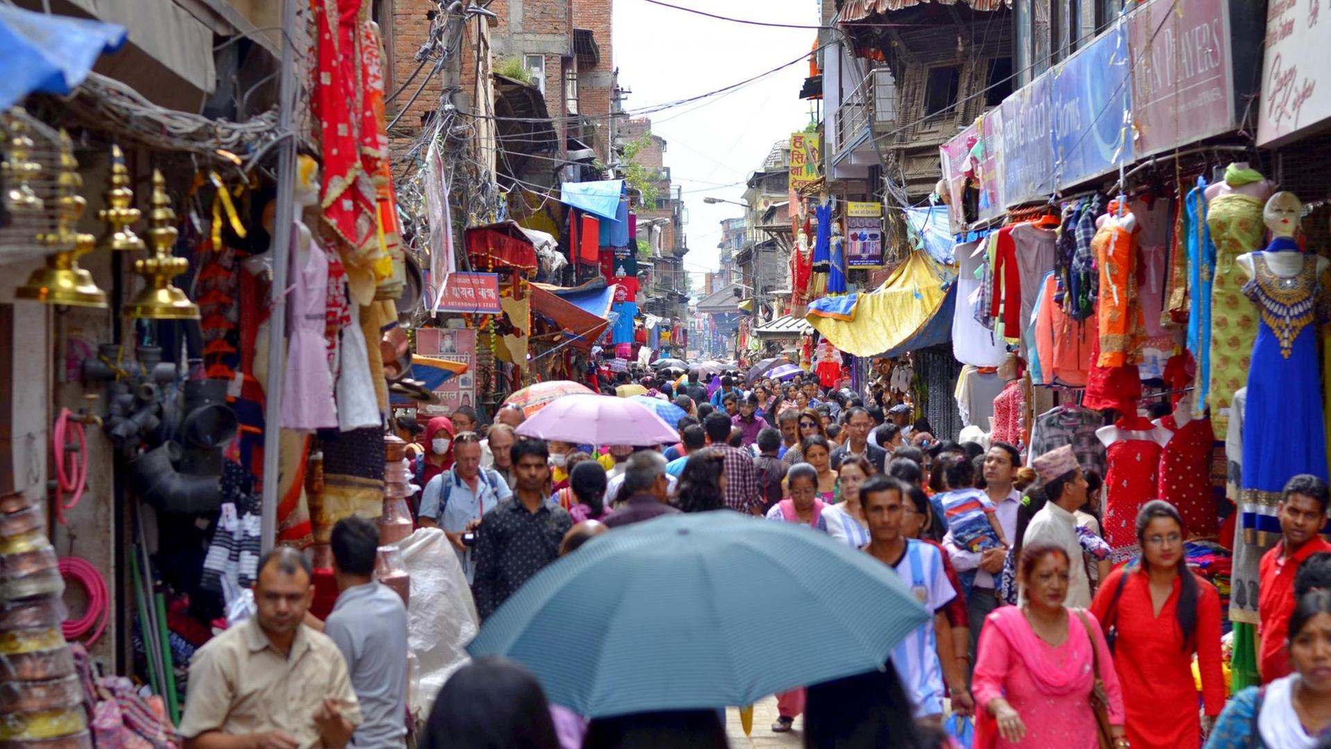 Viele Menschen drängen sich auf einer Straße in Kathmandu.