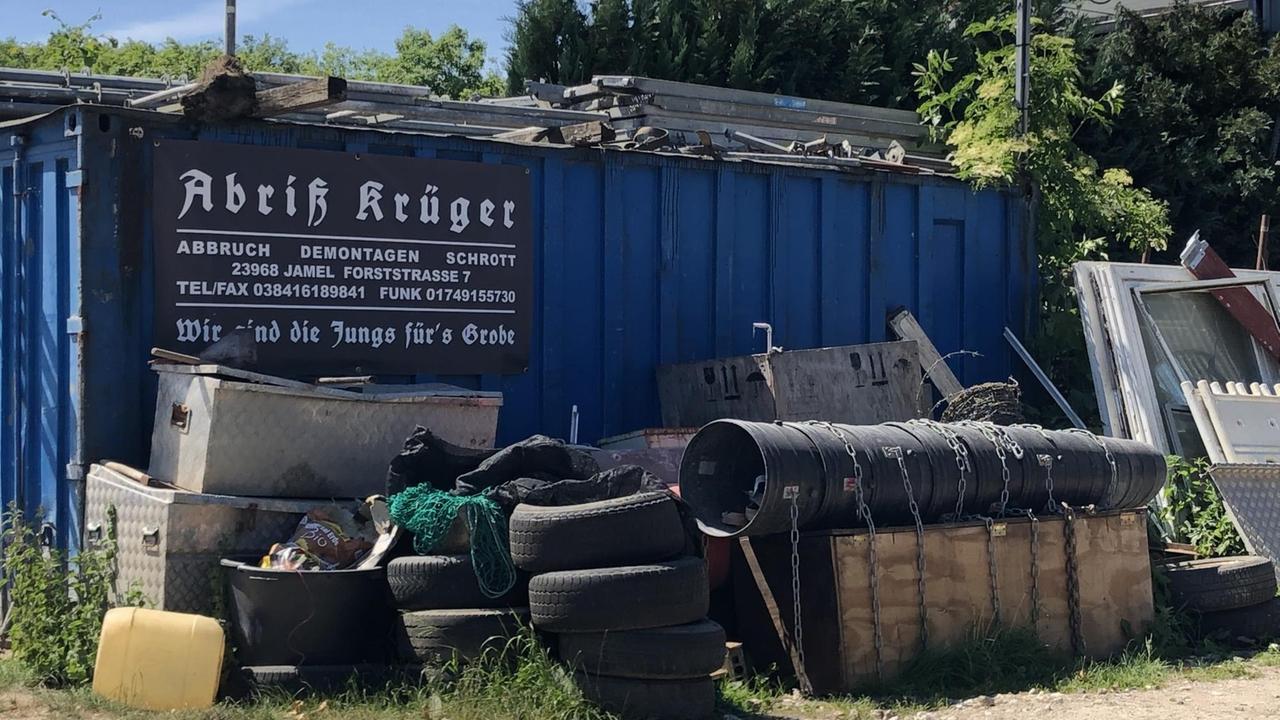An einem Container ist das Schild "Abriß Krüger" angebracht, davor steht Sperrmüll und Gerümpel. An einem Container ist das Schild "Abriß Krüger" angebracht, davor steht Sperrmüll und Gerümpel.