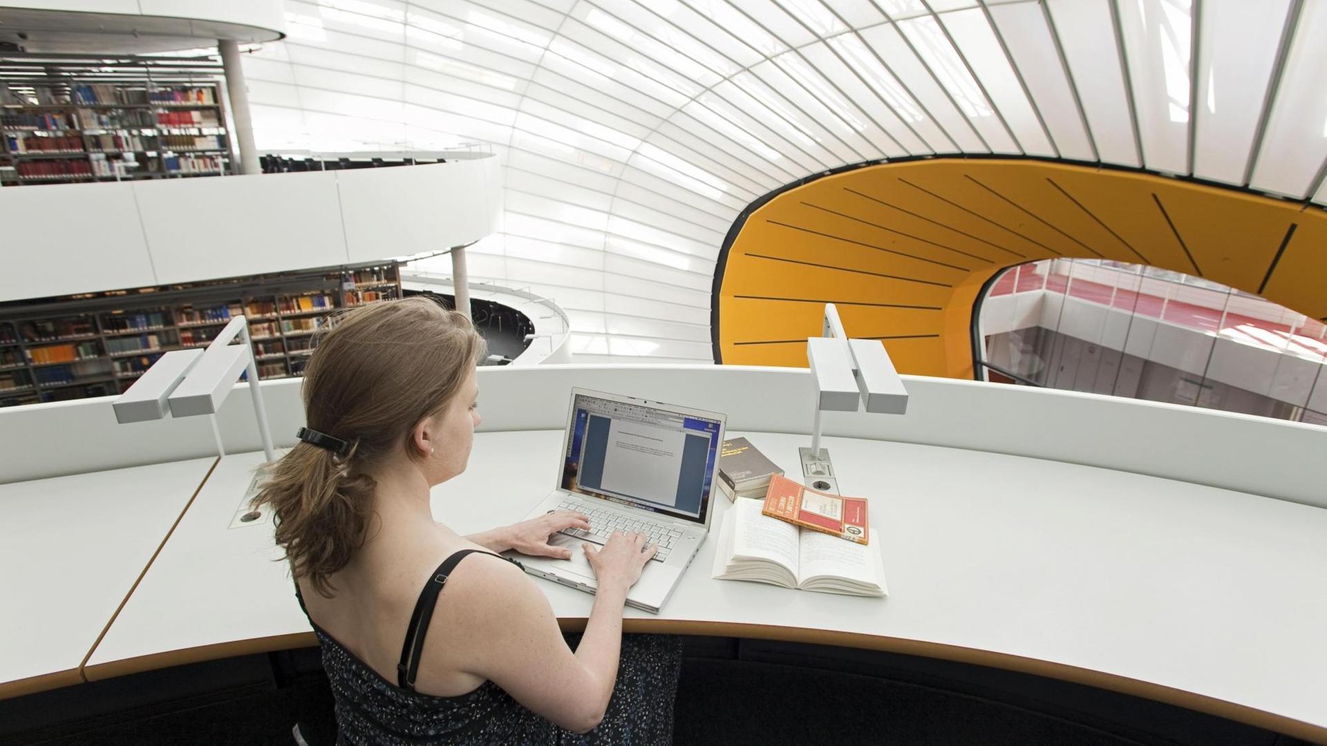 Studentin bei der Arbeit in der Neuen Philologischen Bibliothek der Freien Universität, Berlin, entworfen von Norman Foster. Studentin bei der Arbeit in der Neuen Philologischen Bibliothek der Freien Universität, Berlin, entworfen von Norman Foster.