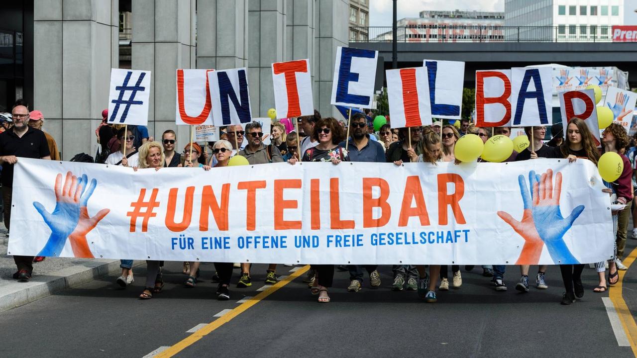 Demo in Berlin - die Demonstranten tragen einen Schriftzug mit der Aufschrift: "Unteilbar - für eine offene und tolerante Gesellschaft". Demo in Berlin - die Demonstranten tragen einen Schriftzug mit der Aufschrift: "Unteilbar - für eine offene und tolerante Gesellschaft".