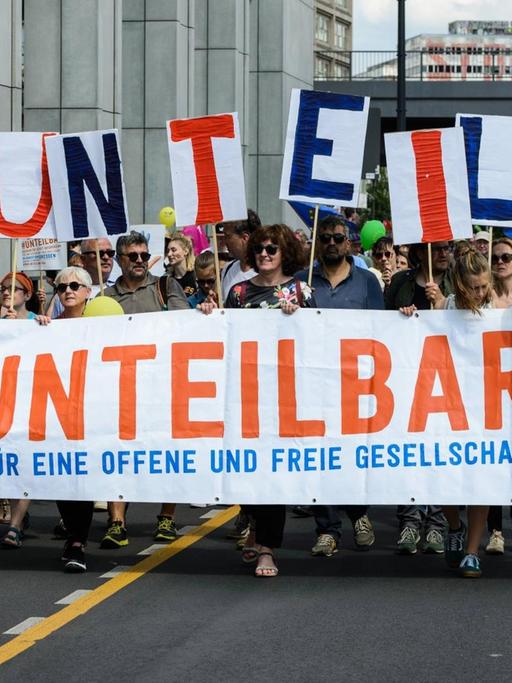 Demo in Berlin - die Demonstranten tragen einen Schriftzug mit der Aufschrift: "Unteilbar - für eine offene und tolerante Gesellschaft".