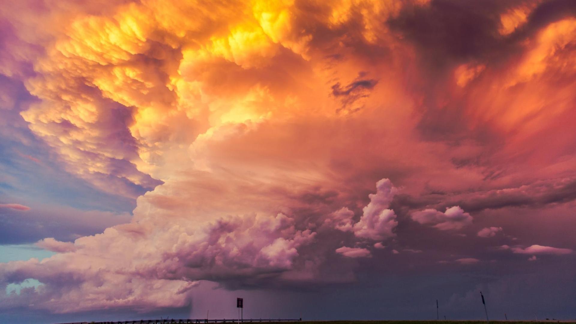 Zur Dämmerung ziehen Wolken auf, deren oberer Teil feuerrot von der untergehenden Sonne beleuchtet ist. Zur Dämmerung ziehen Wolken auf, deren oberer Teil feuerrot von der untergehenden Sonne beleuchtet ist.