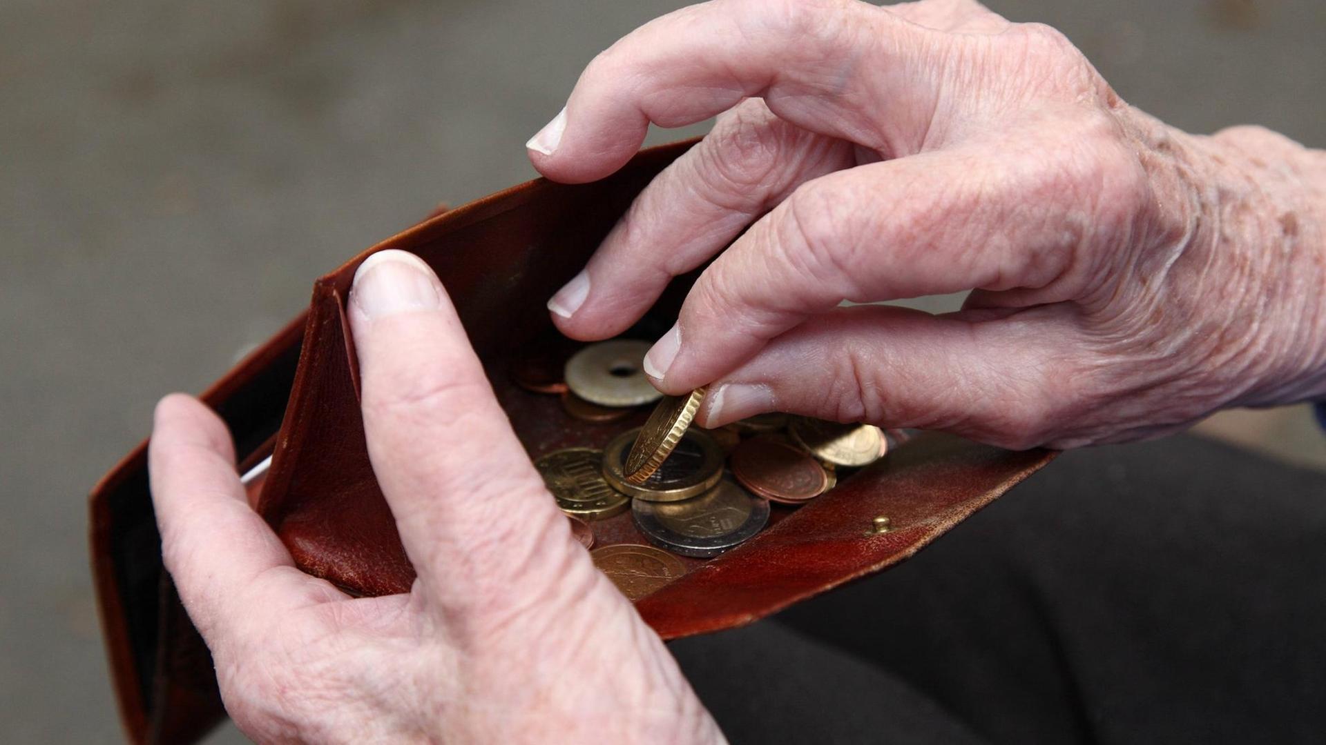 Eine Seniorin hält Geld in ihrer Hand.