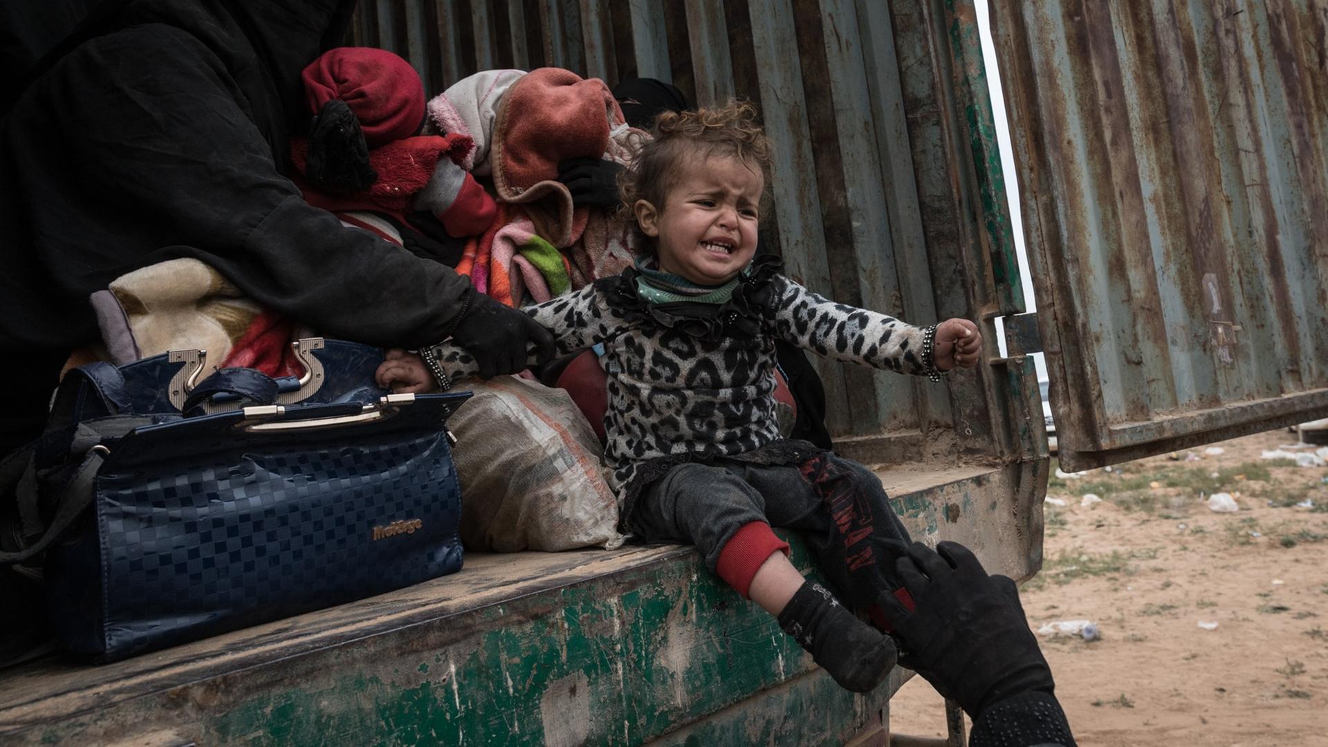 Ein Kind sitzt weinend in einem LKW der kurdischen Miliz YPG in der syrischen Region Baghouz