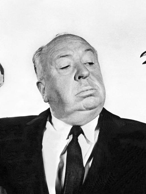 Filmregisseur Alfred Hitchcock mit einer Möwe und einem Raben auf dem Arm