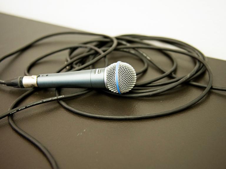 Ein Mikrofon liegt auf einem aufgerollten Kabel