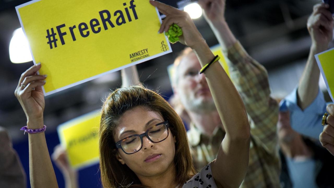 Ensaf Haidar, die Frau des inhaftierten saudische Bloggers Raif Badawi, hält ein Plakat "#FreeRaif" in die Höhe Ensaf Haidar, die Frau des inhaftierten saudische Bloggers Raif Badawi, hält ein Plakat "#FreeRaif" in die Höhe