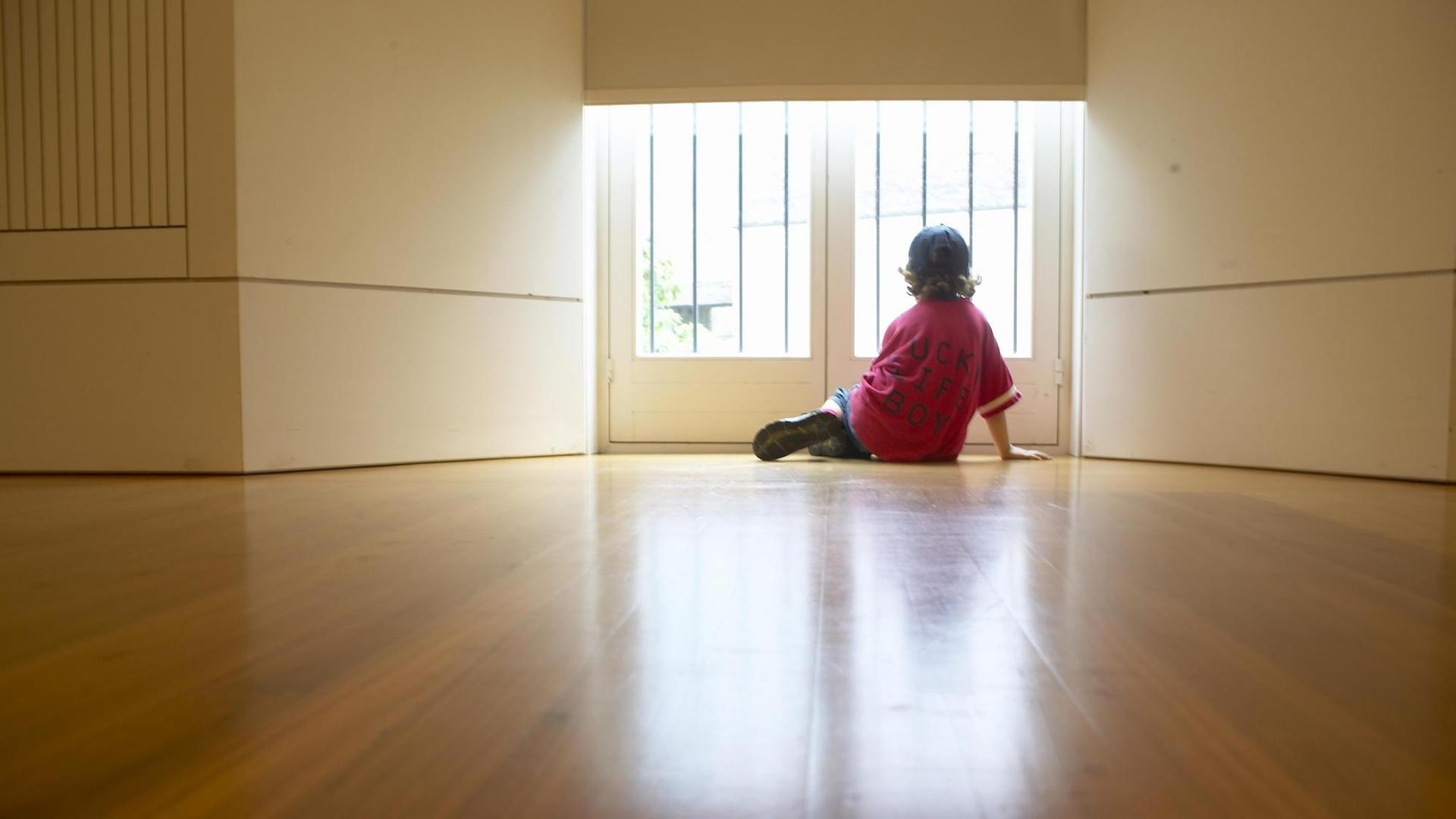 Junge am Fenster blickt nach draußen Junge am Fenster blickt nach draußen