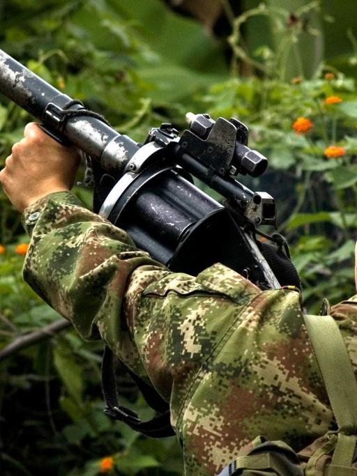 A member of the Colombian guerilla FARC holding his weapon in the mountains of Cauca, Colombia, May 30, 2010. Colombian president Santos confirmed to the media in Bogota, Colombia, 27 August 2012, the agreement to negotiation talks with the Revolutionary Armed Forces of Colombia (FARC). (Zu dpa "Kolumbien will mit Farc-Rebellen über Frieden verhandeln"). Photo: Joana Toro/dpa/aa