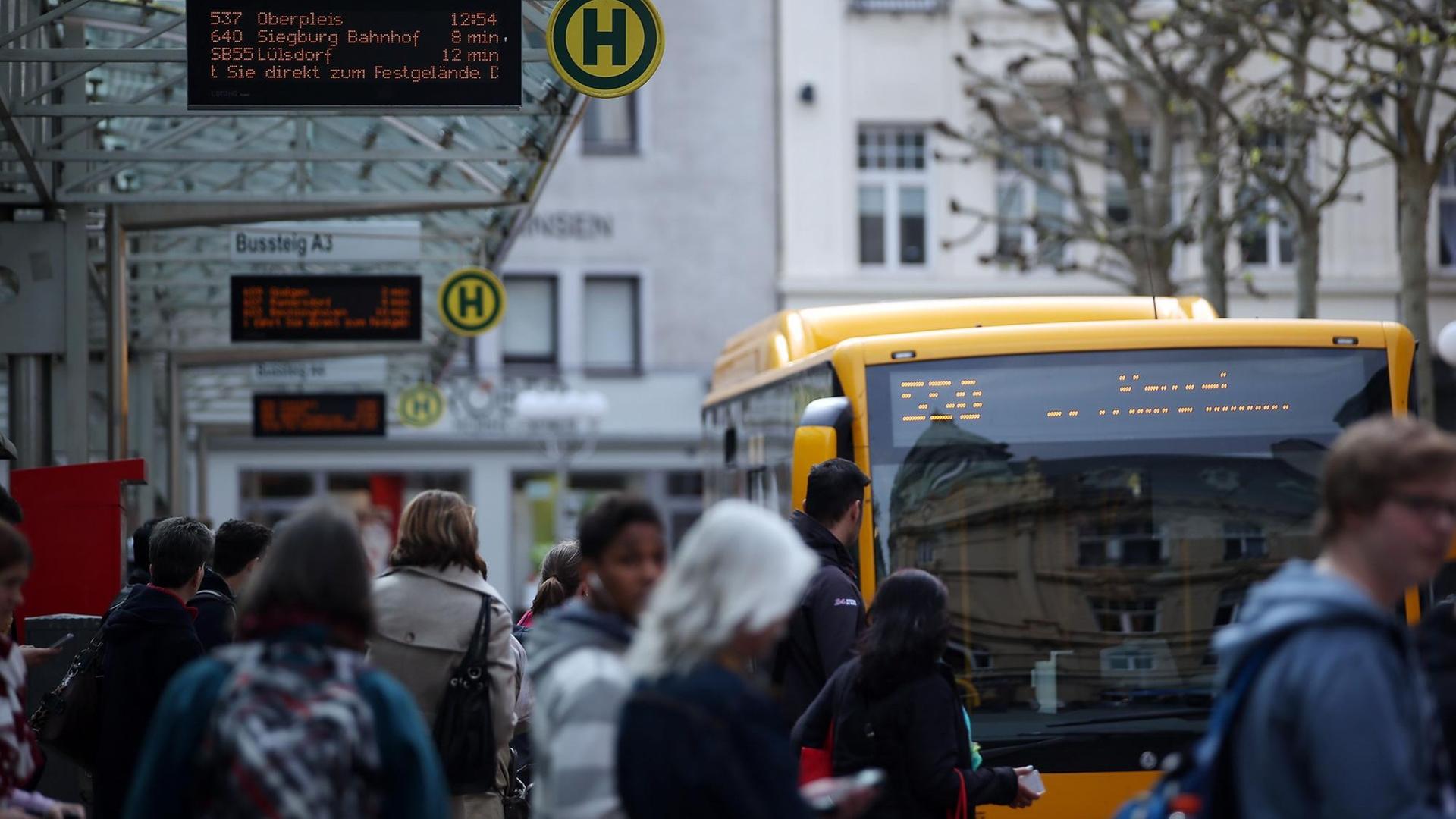 Menschen warten an einer Bushaltestelle in Bonn. Menschen warten an einer Bushaltestelle in Bonn.