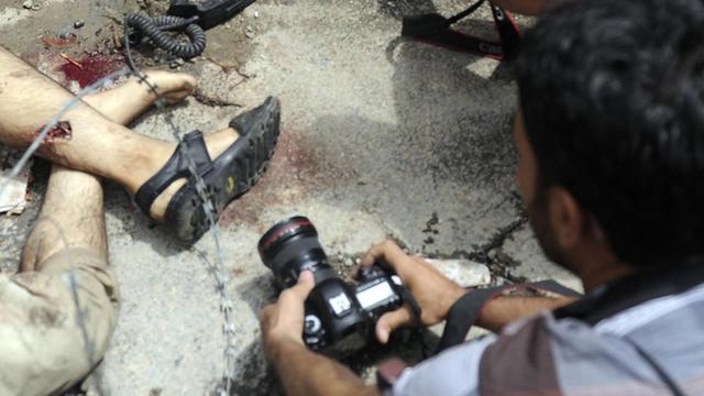 Afghanische Journalisten fotografieren am 22. Juni 2015 die Leichen von Taliban, die einen Anschlag auf das Parlament in Kabul verübt hatten.