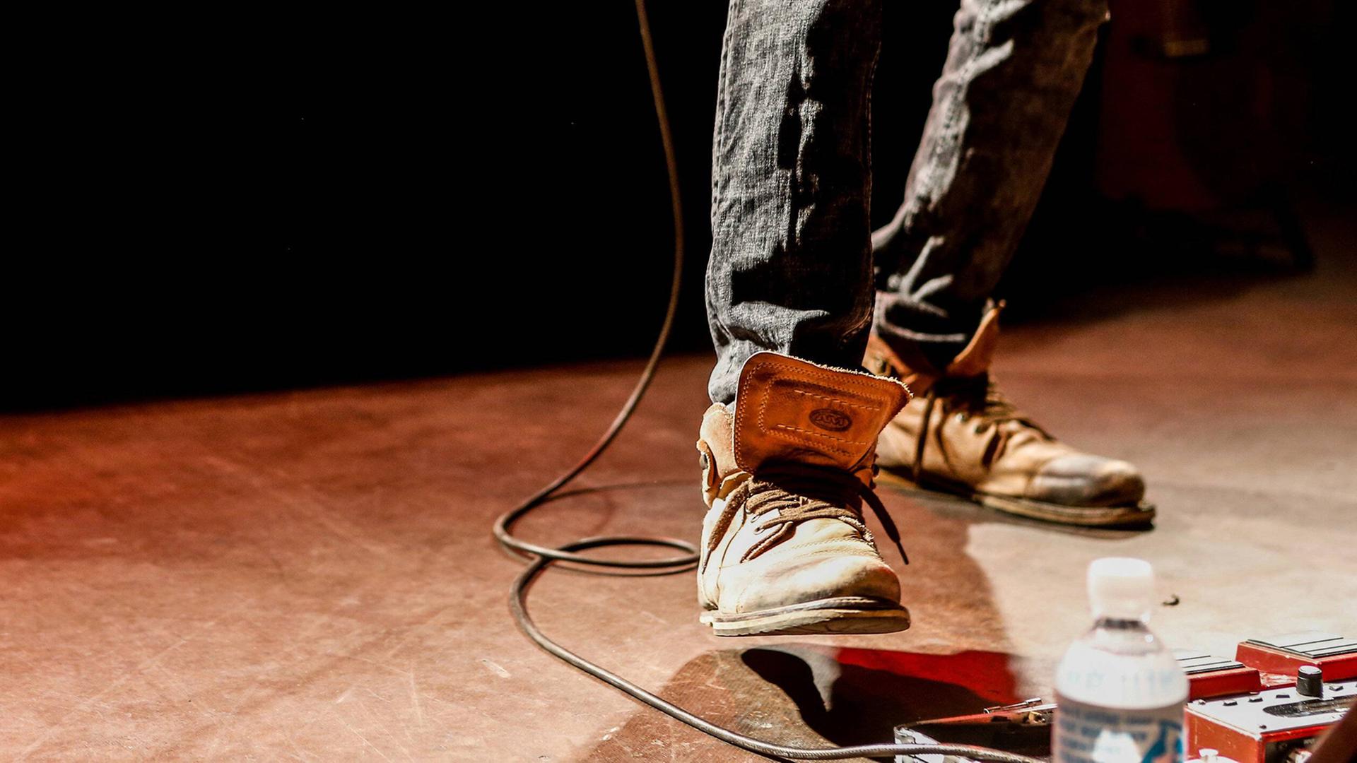 Der Fuß eines Gitarristen auf einem Effektpedal. Der Fuß eines Gitarristen auf einem Effektpedal.