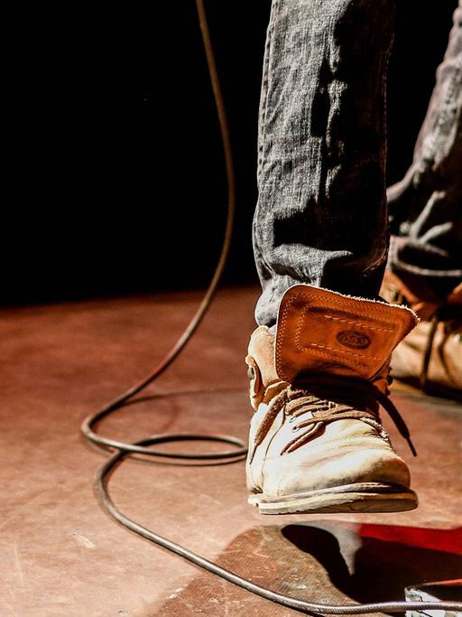 Der Fuß eines Gitarristen auf einem Effektpedal.