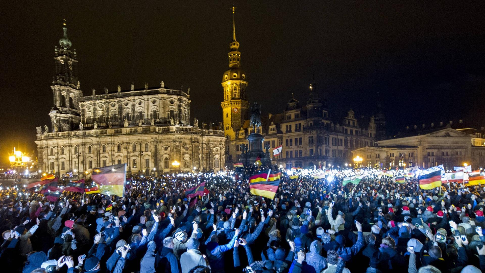 Teilnehmer einer Demonstration des Bündnisses Patriotischer Europäer gegen Islamisierung des Abendlandes (Pegida) sind am Montagabend (22.12.14) auf dem Theaterplatz in Dresden versammelt. Teilnehmer einer Demonstration des Bündnisses Patriotischer Europäer gegen Islamisierung des Abendlandes (Pegida) sind am Montagabend (22.12.14) auf dem Theaterplatz in Dresden versammelt.