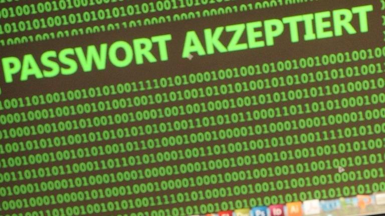 Ein Mensch vor einem Laptop, an dessen Monitor der Schriftzug "Passwort akzeptiert" zu lesen ist. Ein Mensch vor einem Laptop, an dessen Monitor der Schriftzug "Passwort akzeptiert" zu lesen ist.