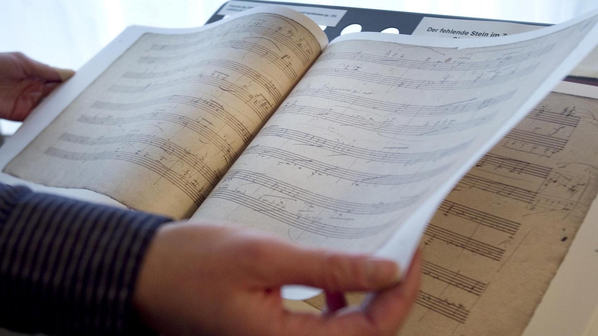 Eine Frau blättert in Bonn in Notenblättern - Faksimile der Diabelli-Variationen von Beethoven.