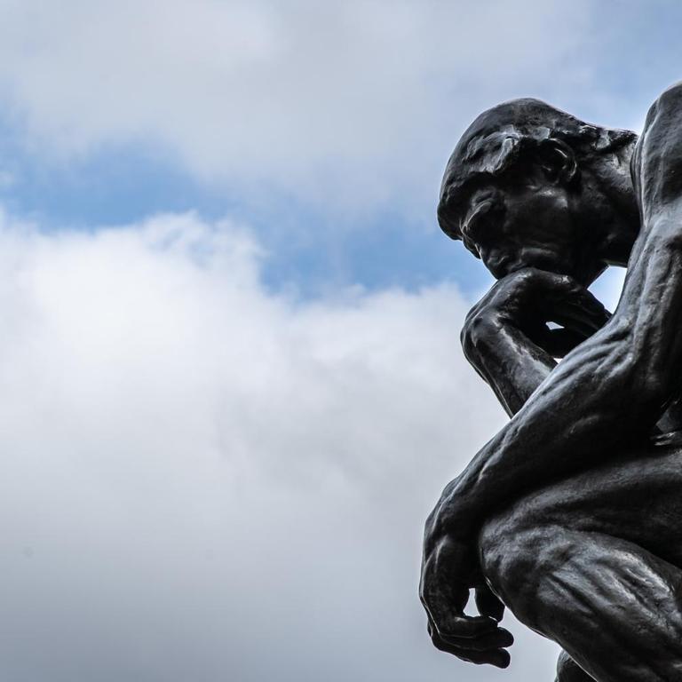 Die Plastik "Der Denker" ("Le Penseur") des Bildhauers Auguste Rodin vor wolkenverhangenen Himmel
